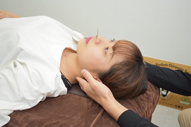 仰向けになって施術を受ける女性